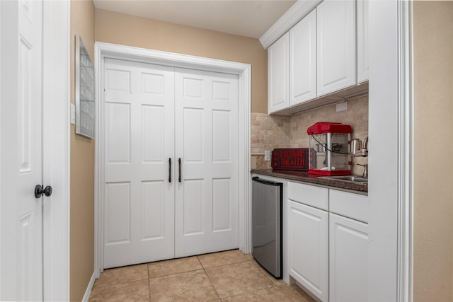 20687 Lavone Dr, Porter, TX 77365 - kitchen featuring a sink, dark countertops, decorative backsplash, white cabinetry, and light tile patterned flooring