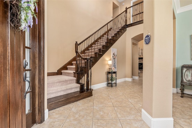 20687 Lavone Dr, Porter, TX 77365 - tiled foyer with arched walkways, stairway, a high ceiling, and baseboards