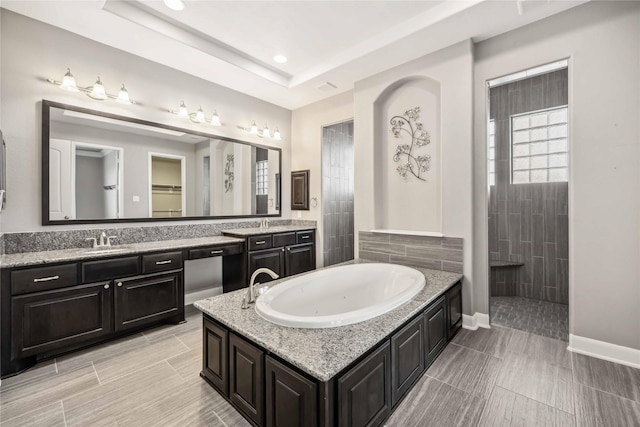 25034 Jennifer Heights Ct, Spring, TX 77389 - bathroom featuring a garden tub, vanity, baseboards, recessed lighting, and a tray ceiling