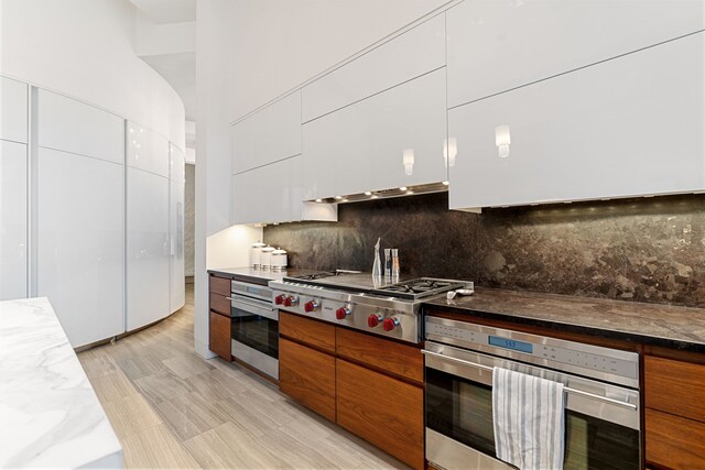 15618 Oyster Cove Dr, Sugar Land, TX 77478 - kitchen with appliances with stainless steel finishes, modern cabinets, white cabinetry, and backsplash