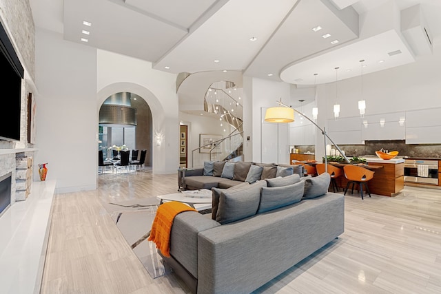 15618 Oyster Cove Dr, Sugar Land, TX 77478 - living area featuring stairway, a towering ceiling, arched walkways, recessed lighting, and a fireplace