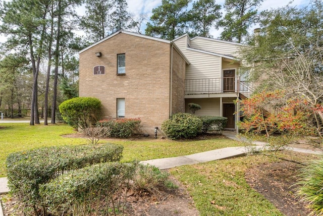 3500 Tangle Brush Dr Unit 7, The Woodlands, TX 77381 - view of home's exterior featuring a lawn, brick siding, and a balcony