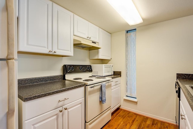 3500 Tangle Brush Dr Unit 7, The Woodlands, TX 77381 - kitchen with dark countertops, white cabinetry, under cabinet range hood, and white appliances