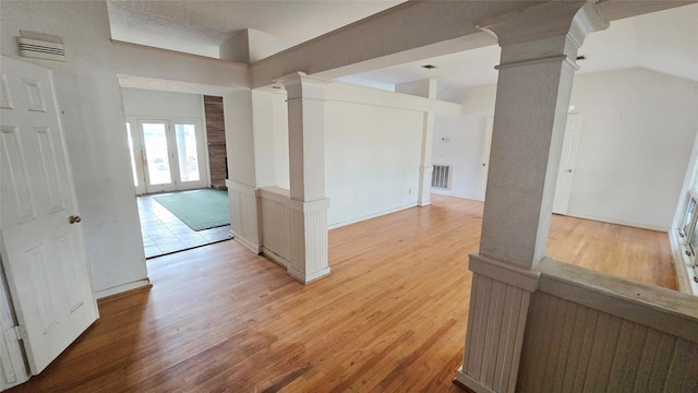 interior space with light wood-style flooring and decorative columns