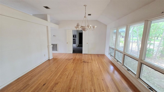 unfurnished dining area with visible vents, light wood-type flooring, baseboards, a notable chandelier, and lofted ceiling