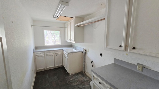 laundry area with a sink, hookup for an electric dryer, and cabinet space
