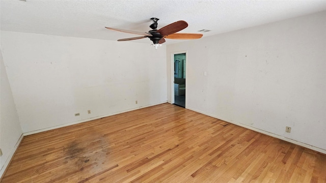 empty room featuring ceiling fan, visible vents, baseboards, and light wood-style floors