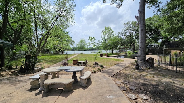 view of patio featuring a water view and fence