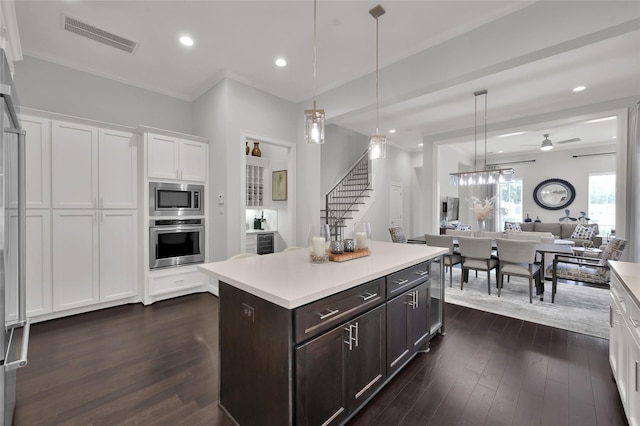 258 Green Blvd, Shenandoah, TX 77384 - kitchen featuring white cabinets, dark brown cabinets, appliances with stainless steel finishes, light countertops, and visible vents
