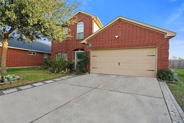 traditional-style home with brick siding, a garage, driveway, and a front yard