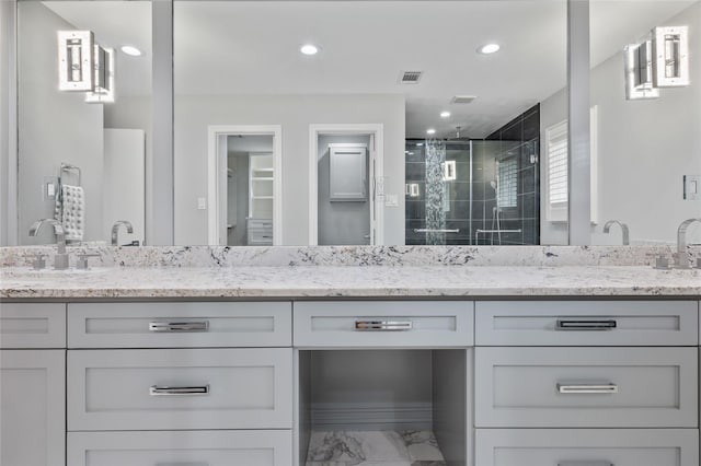 full bath with a sink, double vanity, marble finish floor, visible vents, and a stall shower