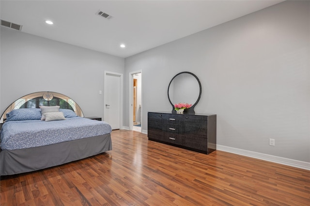 bedroom with baseboards, recessed lighting, wood finished floors, and visible vents