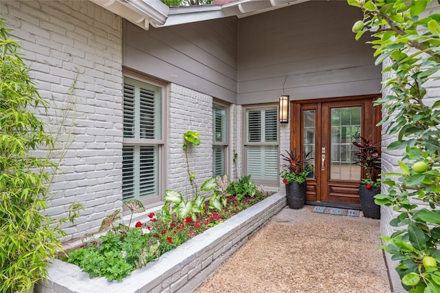 view of exterior entry with brick siding