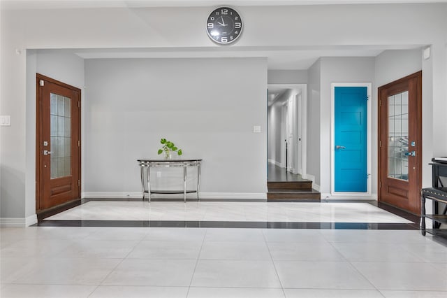 foyer entrance with tile patterned floors and baseboards