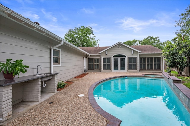 view of swimming pool featuring a fenced in pool, an in ground hot tub, a patio area, french doors, and a sink
