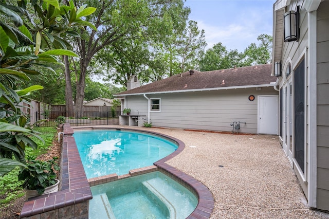 view of swimming pool with a patio, fence, and a pool with connected hot tub