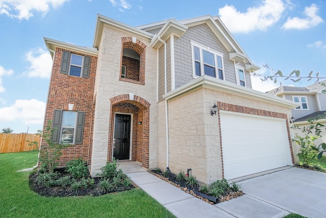 view of front of property featuring a garage, fence, a front yard, stone siding, and driveway