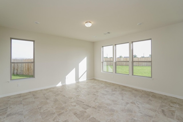 spare room with baseboards and visible vents