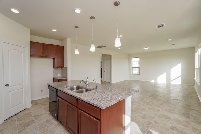 kitchen with visible vents, an island with sink, a sink, dishwasher, and hanging light fixtures
