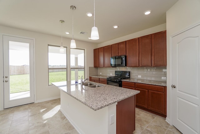 kitchen with visible vents, decorative backsplash, a kitchen island with sink, a sink, and black appliances