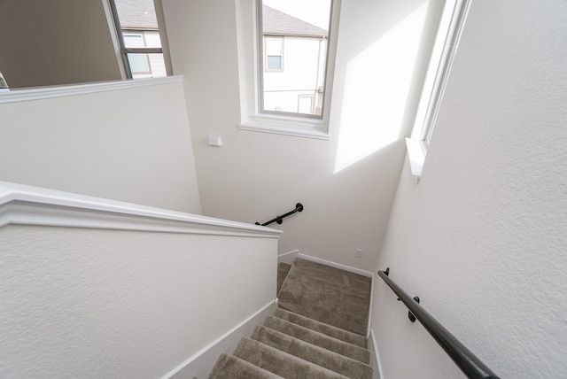 staircase with baseboards, carpet floors, and a wealth of natural light
