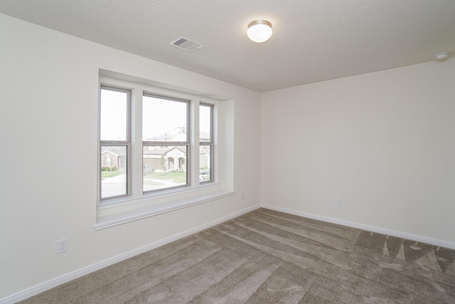 carpeted empty room with baseboards and visible vents