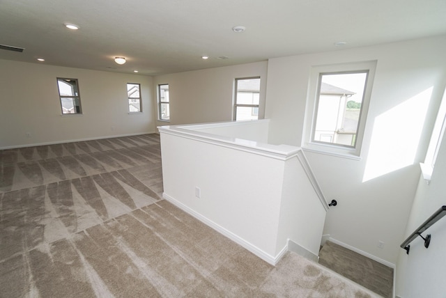 unfurnished room with plenty of natural light, recessed lighting, and light carpet