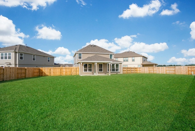 back of property with a lawn and a fenced backyard