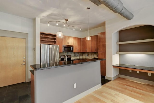 kitchen with open shelves, hanging light fixtures, dark countertops, stainless steel appliances, and decorative backsplash