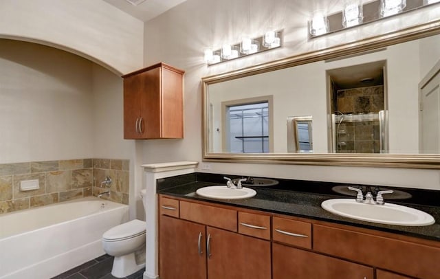 full bath with double vanity, toilet, a tile shower, and a sink
