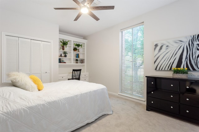 bedroom featuring baseboards, a ceiling fan, a closet, and light colored carpet