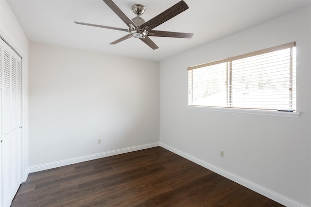 unfurnished bedroom with baseboards, dark wood-style flooring, ceiling fan, and a closet