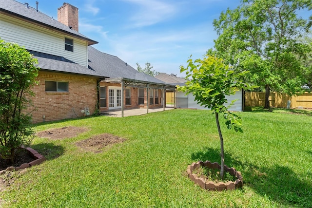 view of yard with fence, french doors, and a patio area