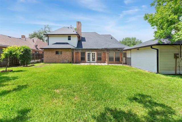 rear view of house with a yard, a pergola, fence, and a chimney