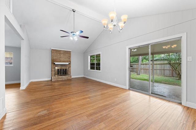 unfurnished living room with a brick fireplace, baseboards, light wood-style flooring, and ceiling fan with notable chandelier