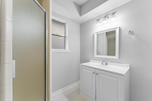 full bathroom with vanity, baseboards, and a stall shower