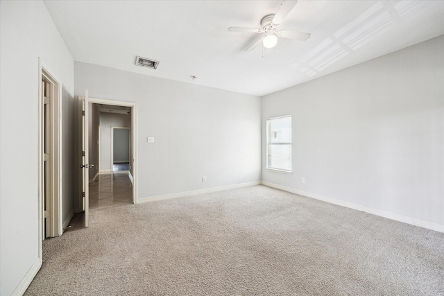 spare room featuring carpet flooring, a ceiling fan, baseboards, and visible vents