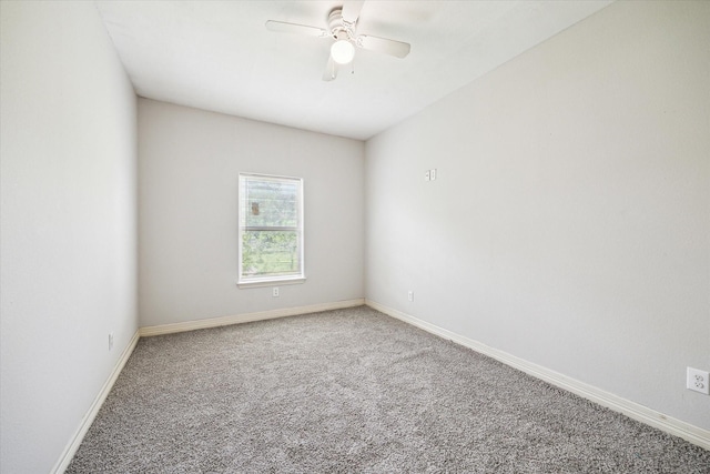 carpeted spare room with baseboards and a ceiling fan