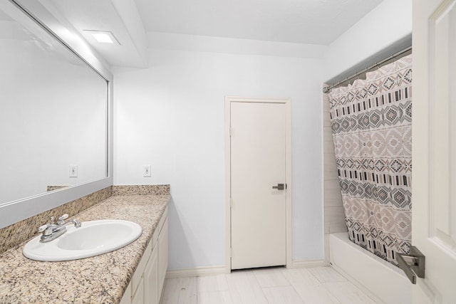 bathroom with vanity, baseboards, and shower / bath combination with curtain