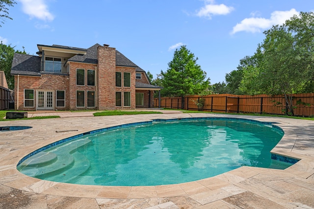 view of pool with french doors, a fenced in pool, a fenced backyard, and a patio area