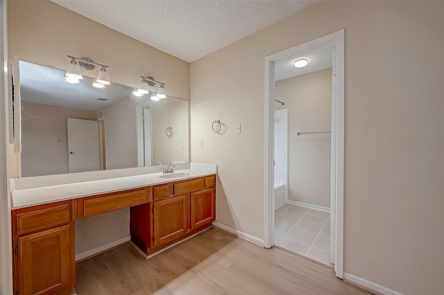 3022 Sam Houston Dr, Sugar Land, TX 77479 - full bathroom featuring vanity, wood finished floors, shower / washtub combination, and a textured ceiling
