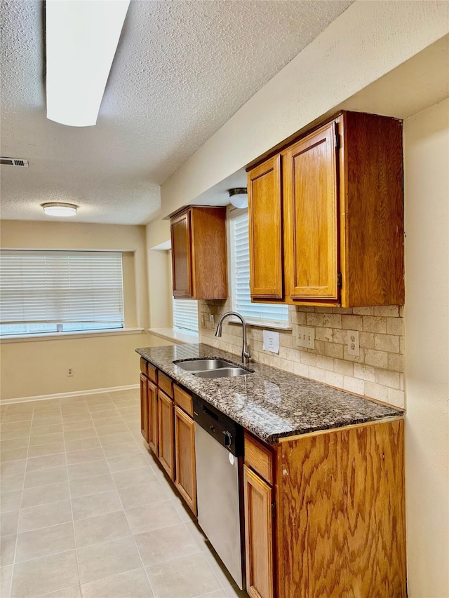 3022 Sam Houston Dr, Sugar Land, TX 77479 - kitchen featuring dishwasher, brown cabinetry, a textured ceiling, tasteful backsplash, and dark stone countertops
