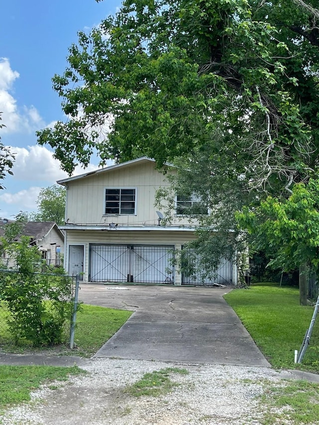 view of front of property featuring an attached garage, a front lawn, and driveway