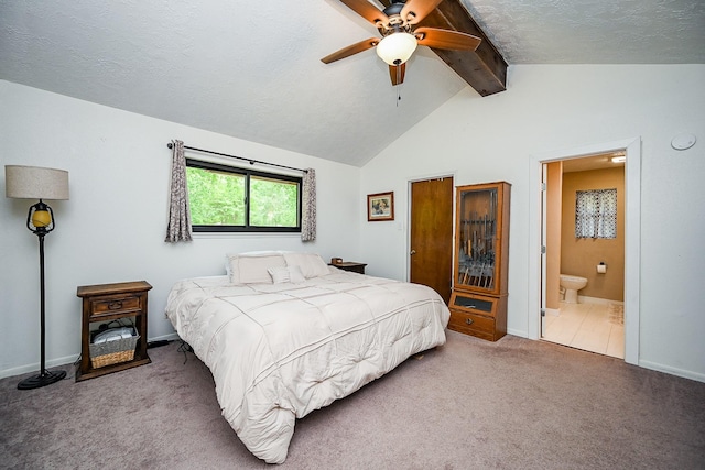 carpeted bedroom featuring ceiling fan, a textured ceiling, baseboards, vaulted ceiling with beams, and ensuite bathroom