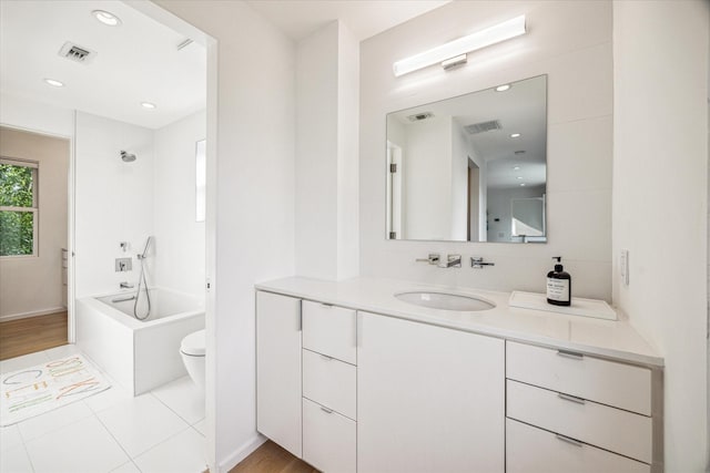 bathroom featuring visible vents, toilet, and vanity