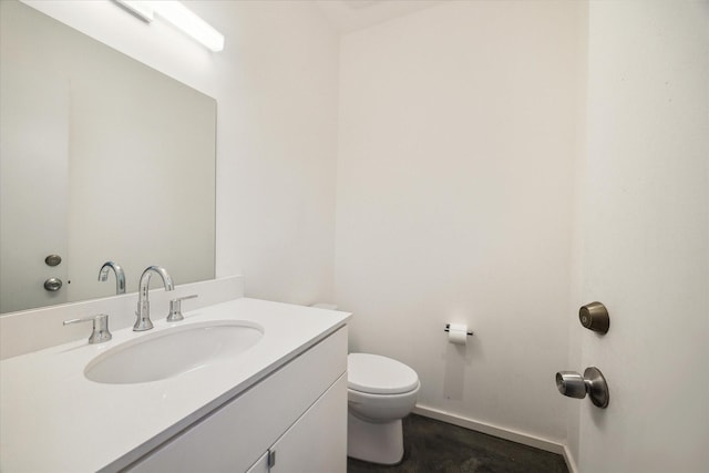 bathroom featuring baseboards, vanity, and toilet
