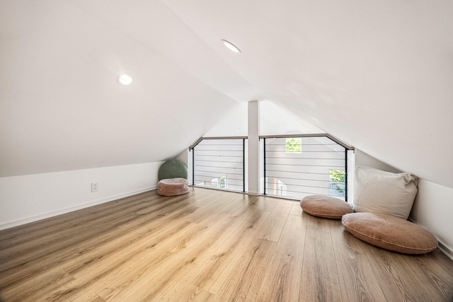 additional living space with wood finished floors, baseboards, and lofted ceiling