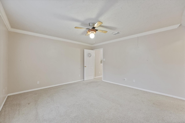 carpeted spare room with visible vents, a ceiling fan, baseboards, and crown molding