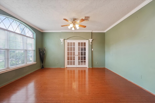 empty room with visible vents, a ceiling fan, a textured ceiling, and wood finished floors