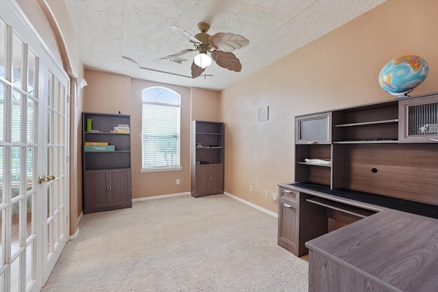 unfurnished office with baseboards, ceiling fan, a textured ceiling, and light colored carpet